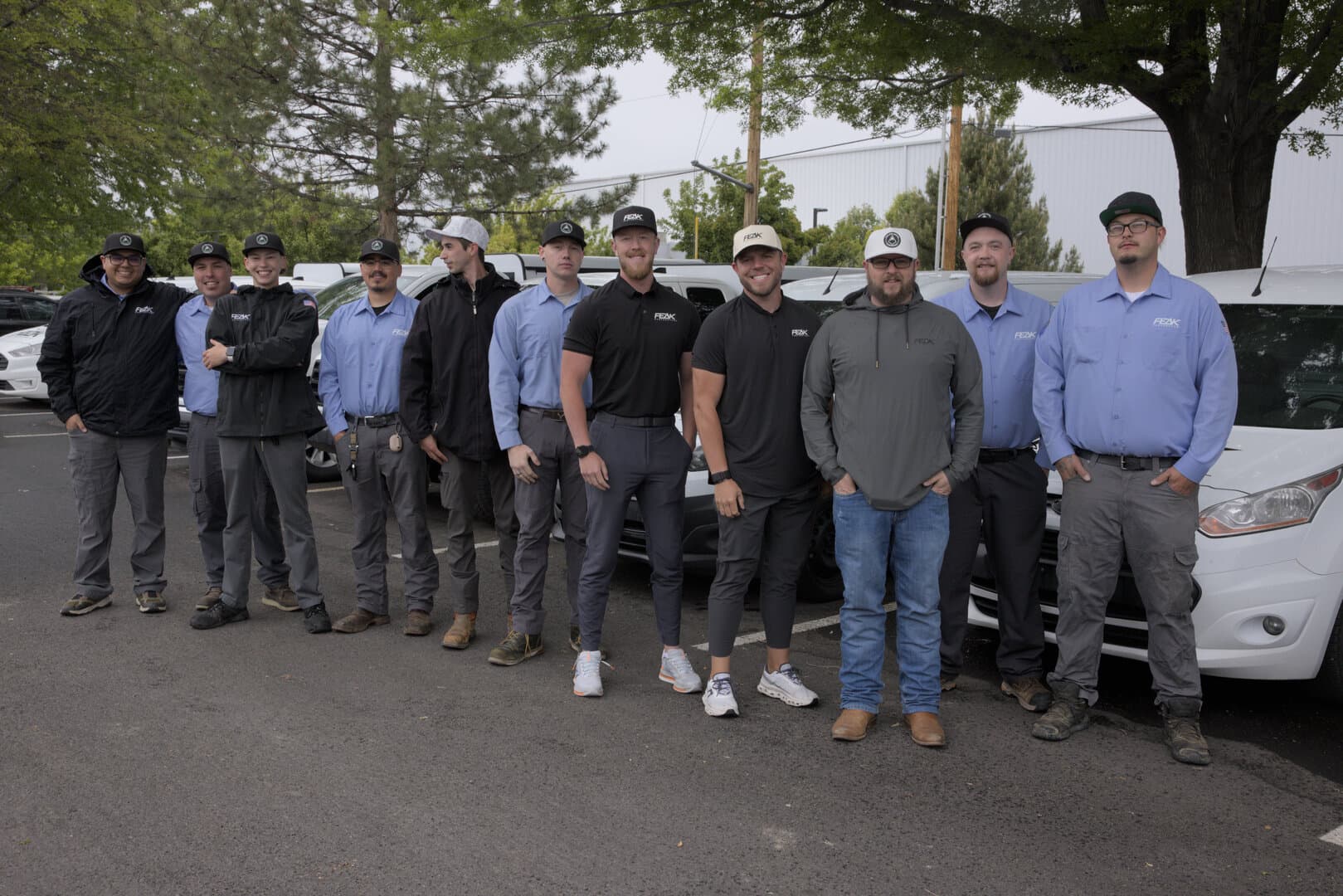 The Peak Pest Control team in front of the company fleet
