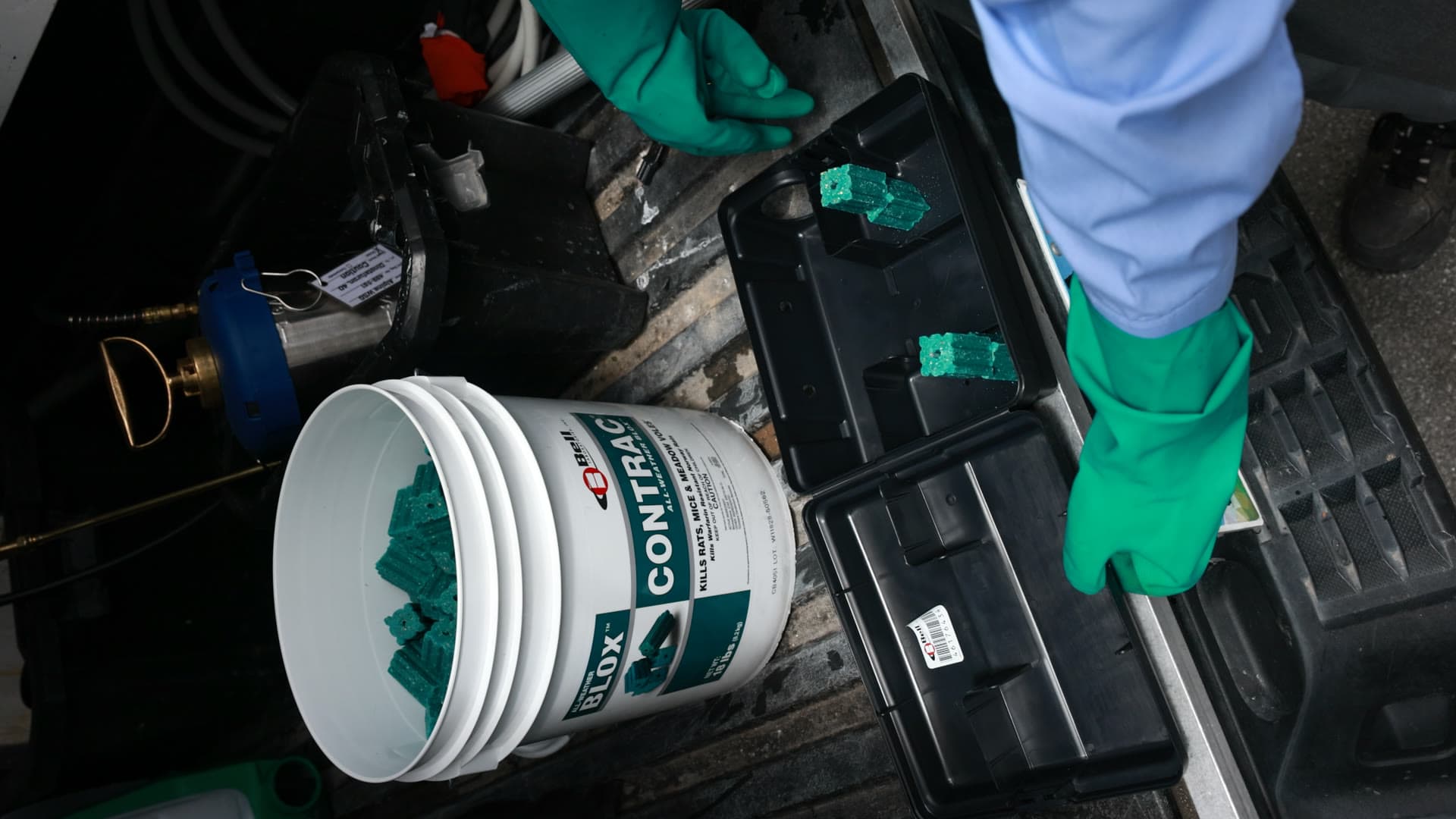 Peak Pest Control technician preparing rodent bait stations for a commercial property